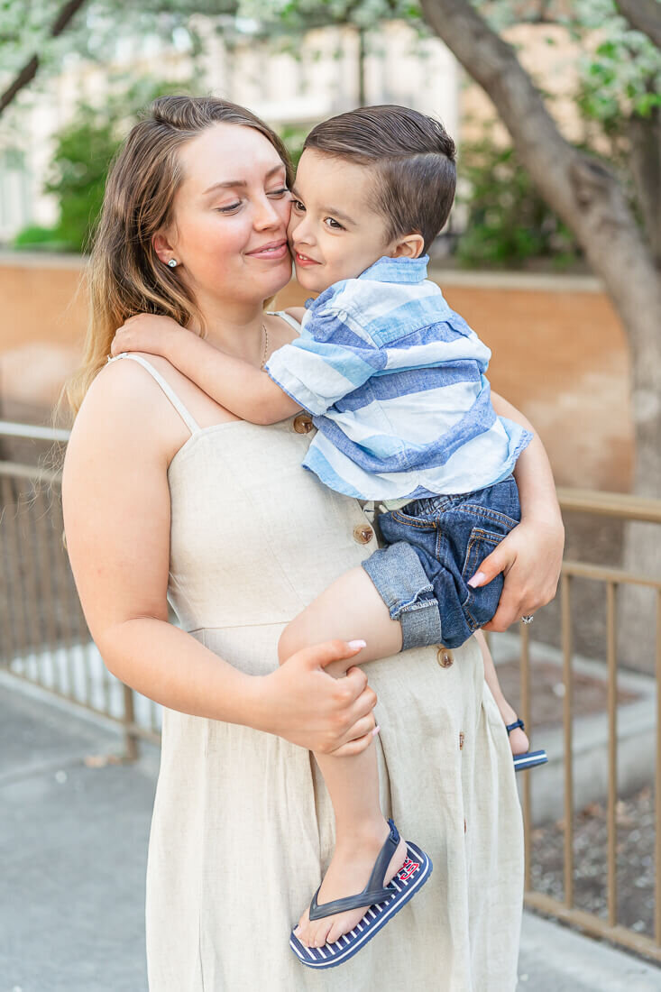 A pregnant woman holds her preschool age son at BYU, Provo in the spring