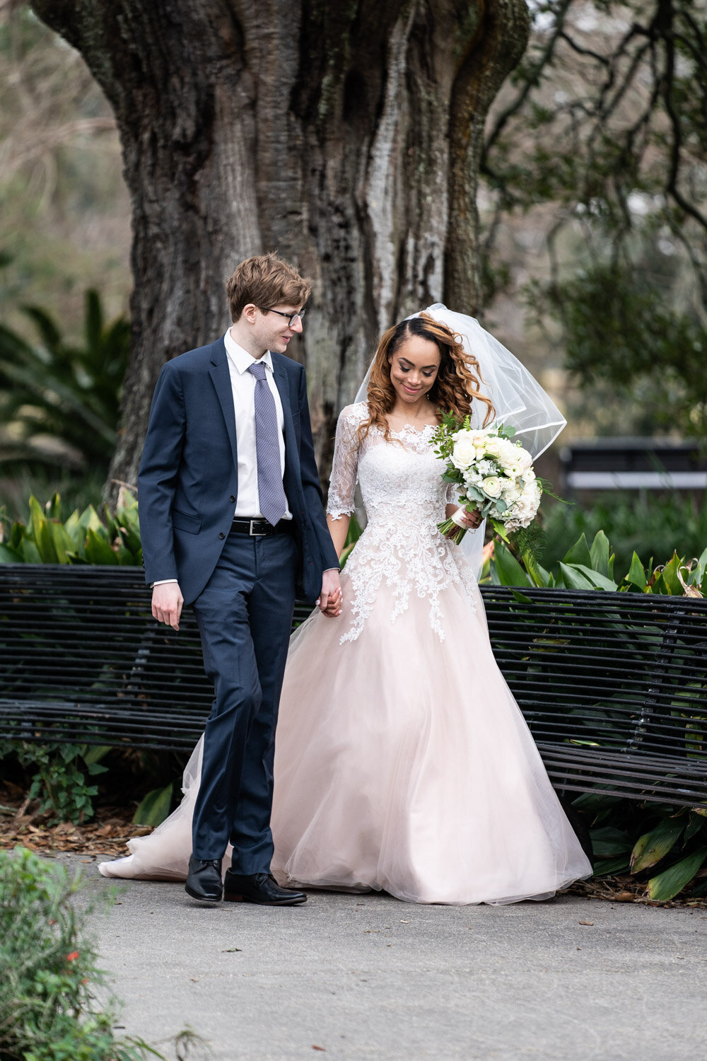 Bride and groom walk through Audubon Park