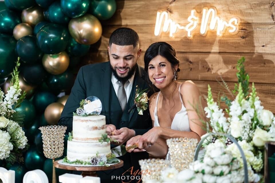 bride and groom cutting cake at table