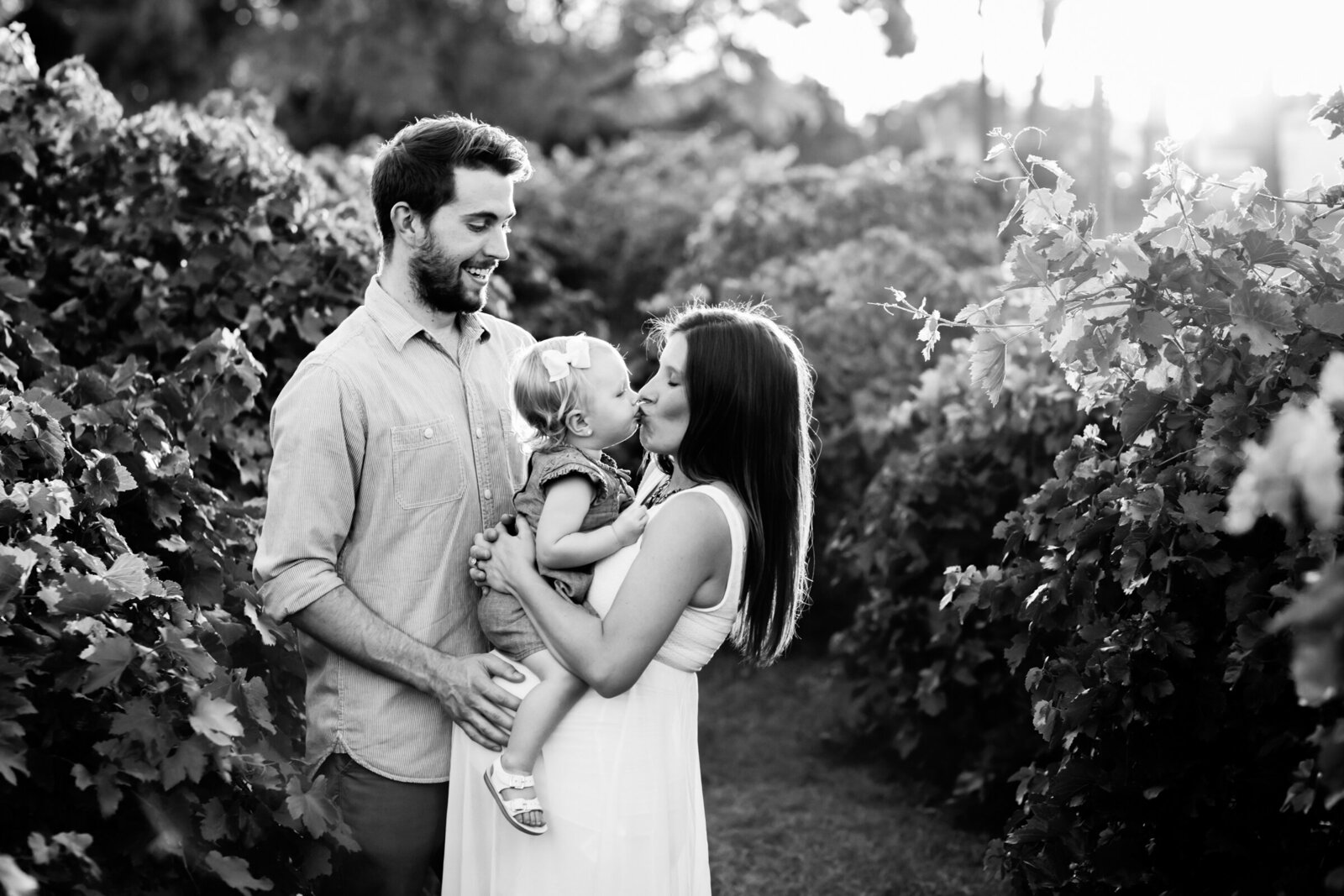 family embracing and holding baby bump