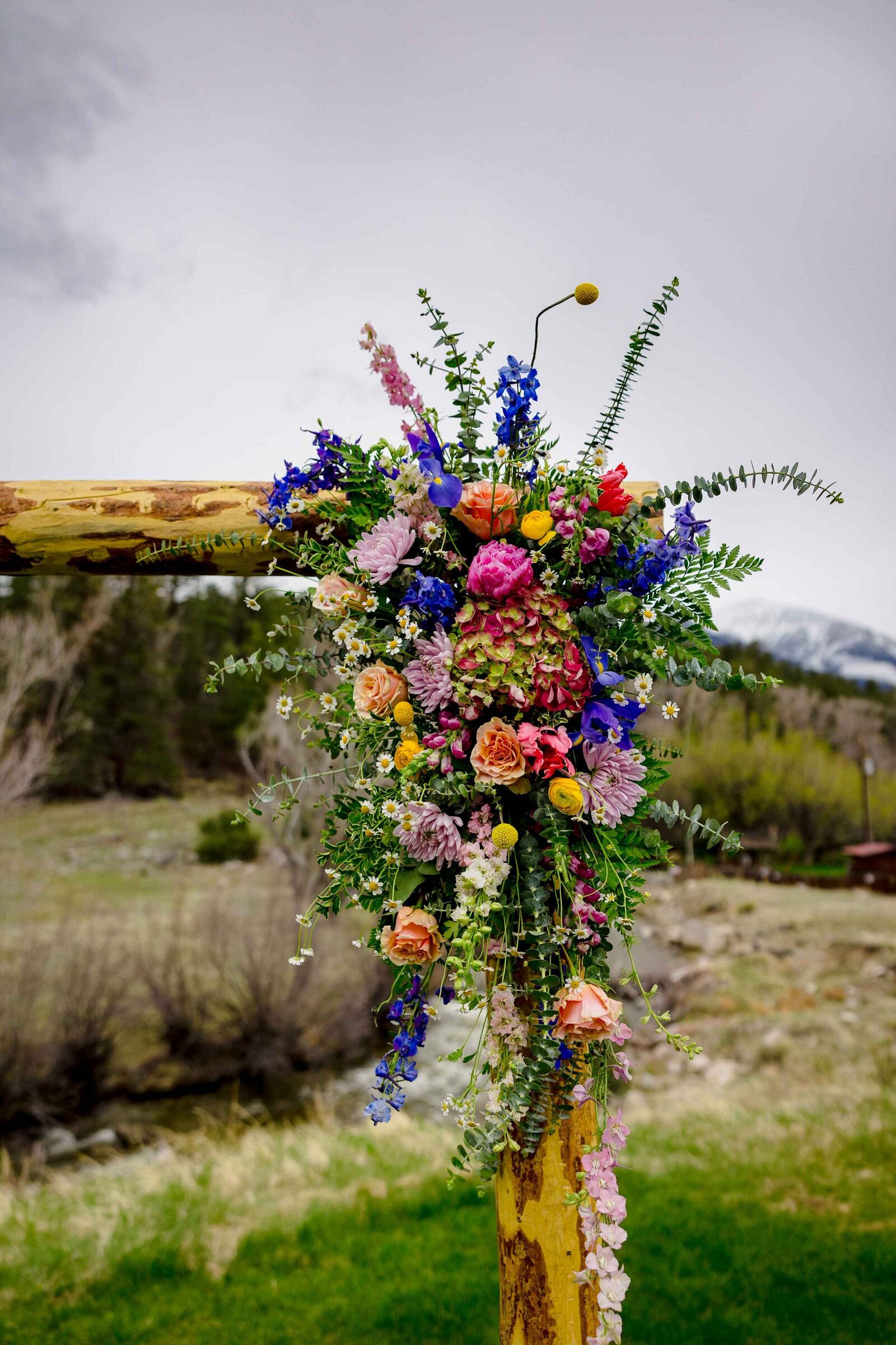A large flower arrangement on a wooden post.