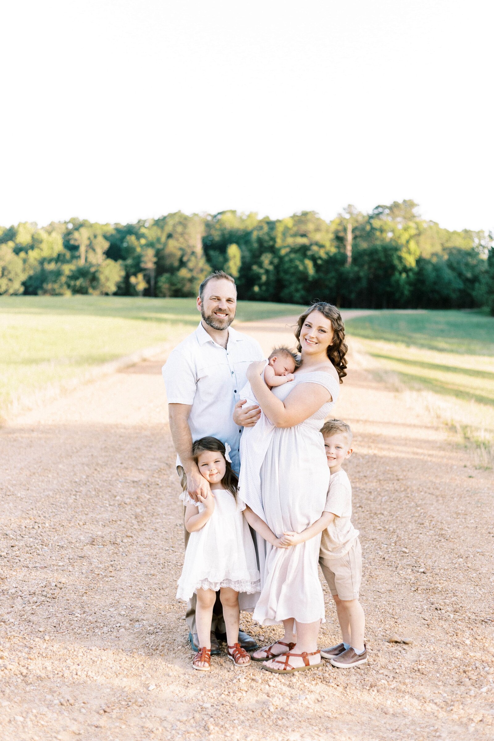 family hugging and smiling outdoors in peoria illinois newborn photos 