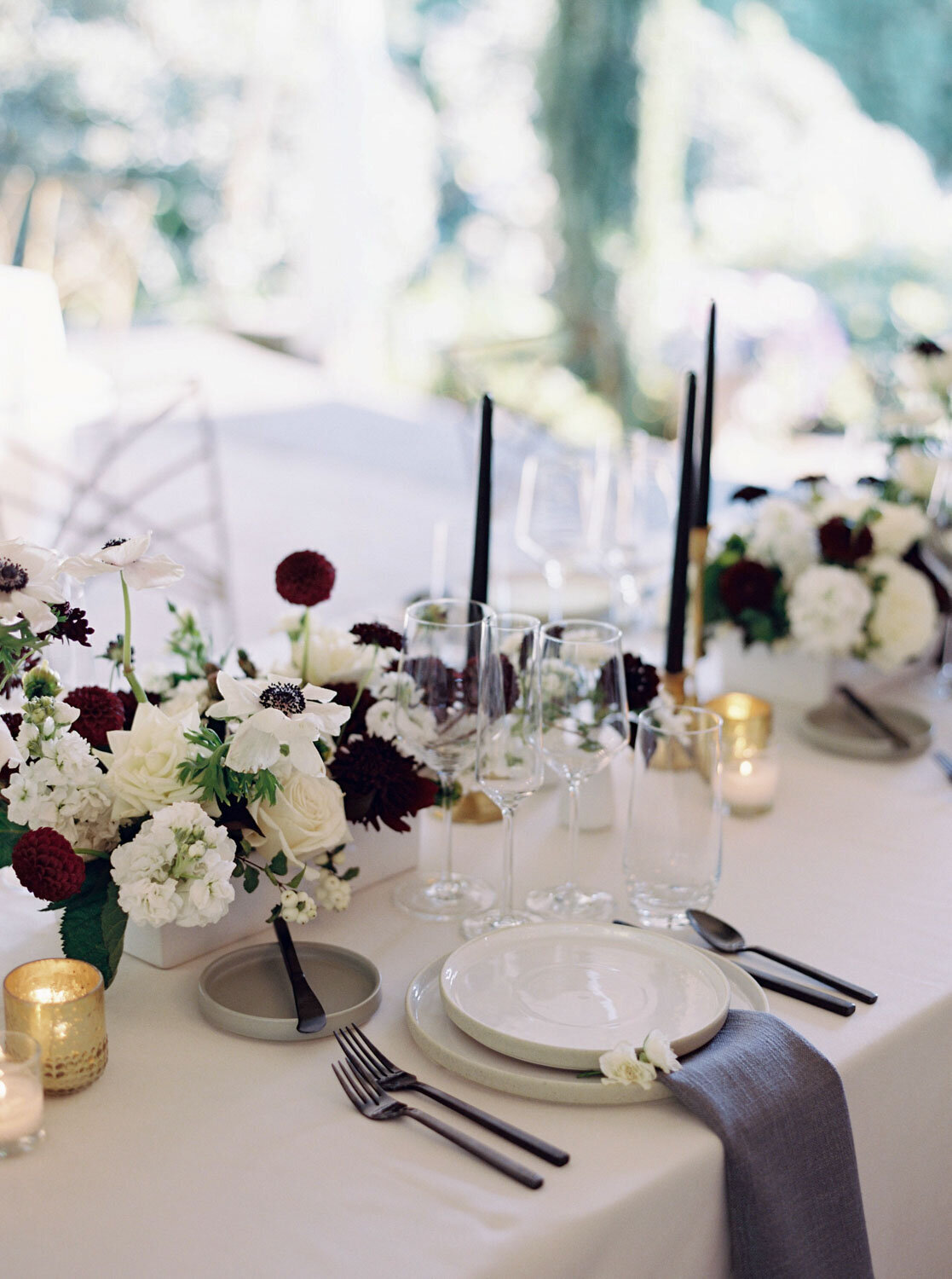 Table setting with floral centerpieces and black candles