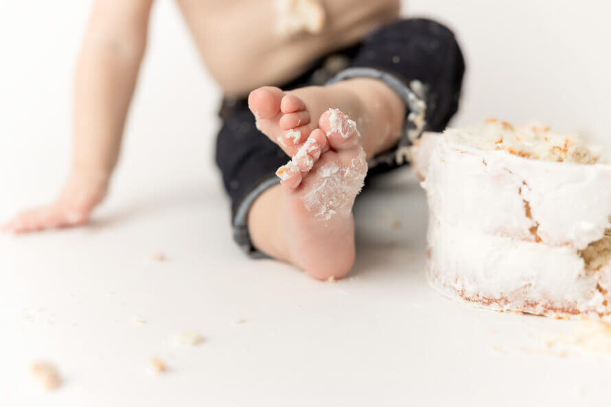 Baby feet with frosting on them during his Cake Smash Photo session.