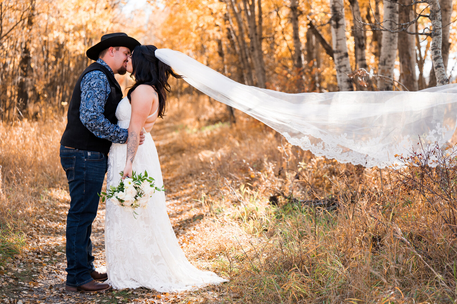 bride and groom kiss, and veil floats in the wind at a country style wedding in Edmonton, Alberta