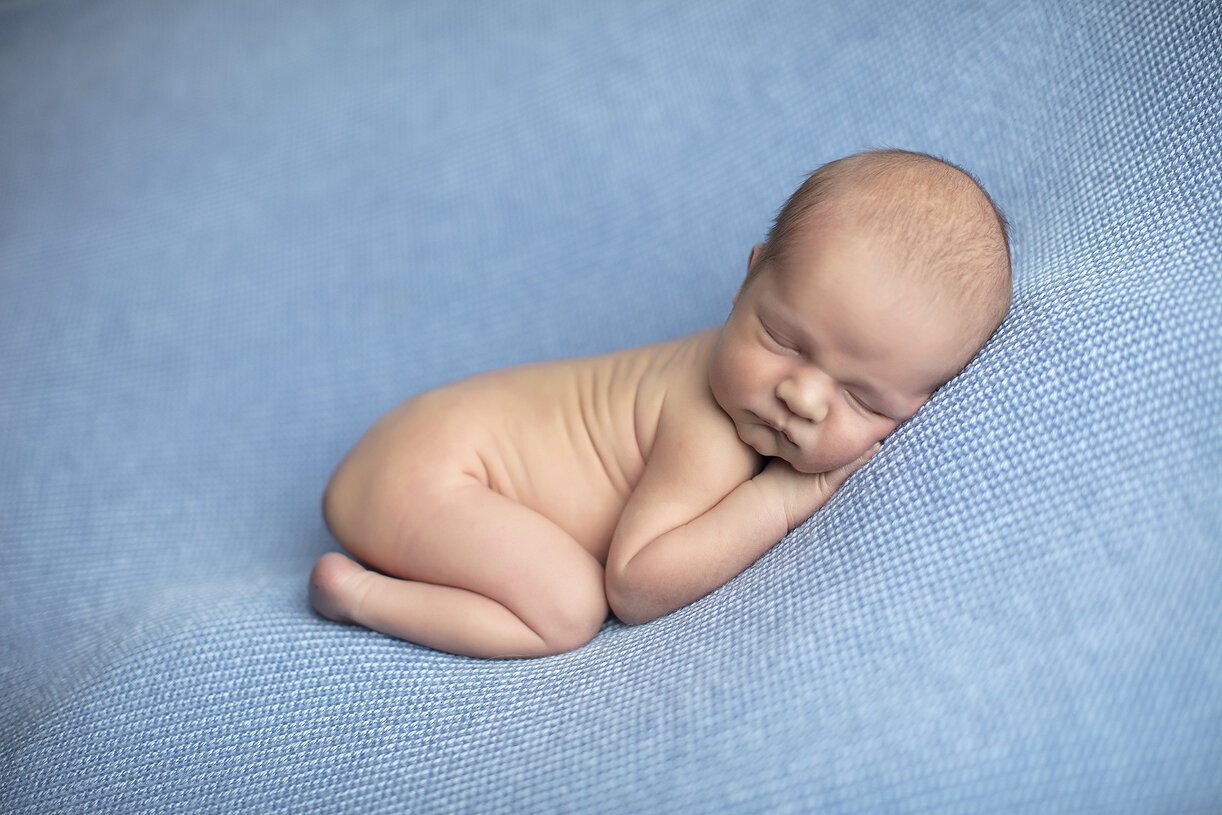 Newborn boy laying on side, a Dallas newborn photographer.