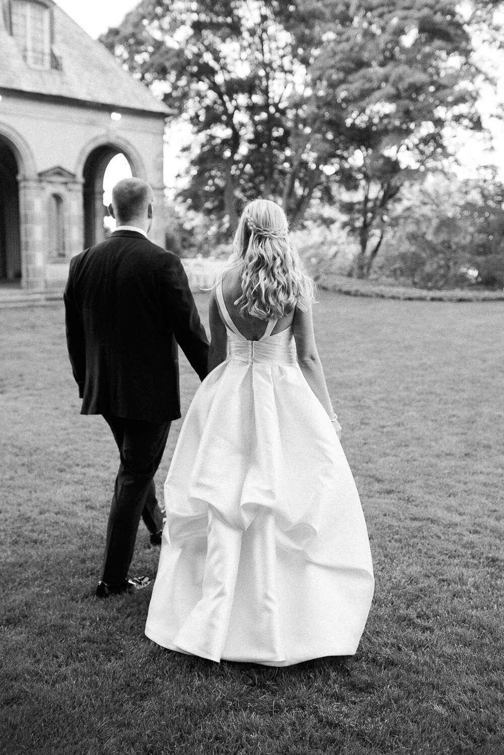 bride and groom walking from behind on lawn