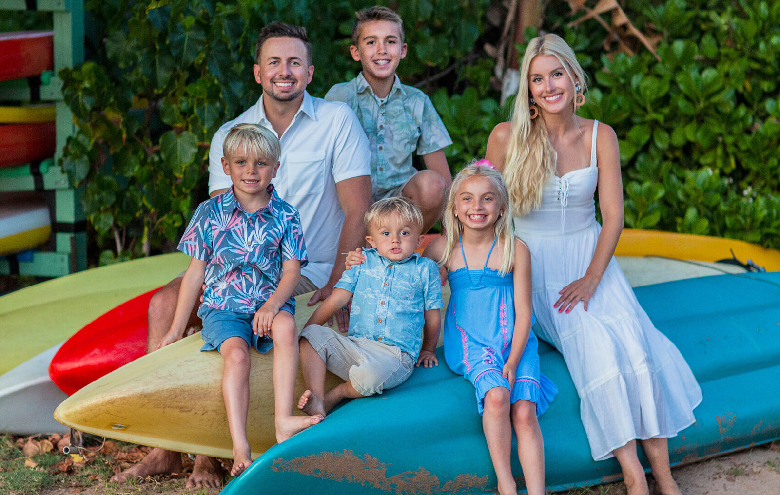 Family six sitting on surfboards in Waikiki