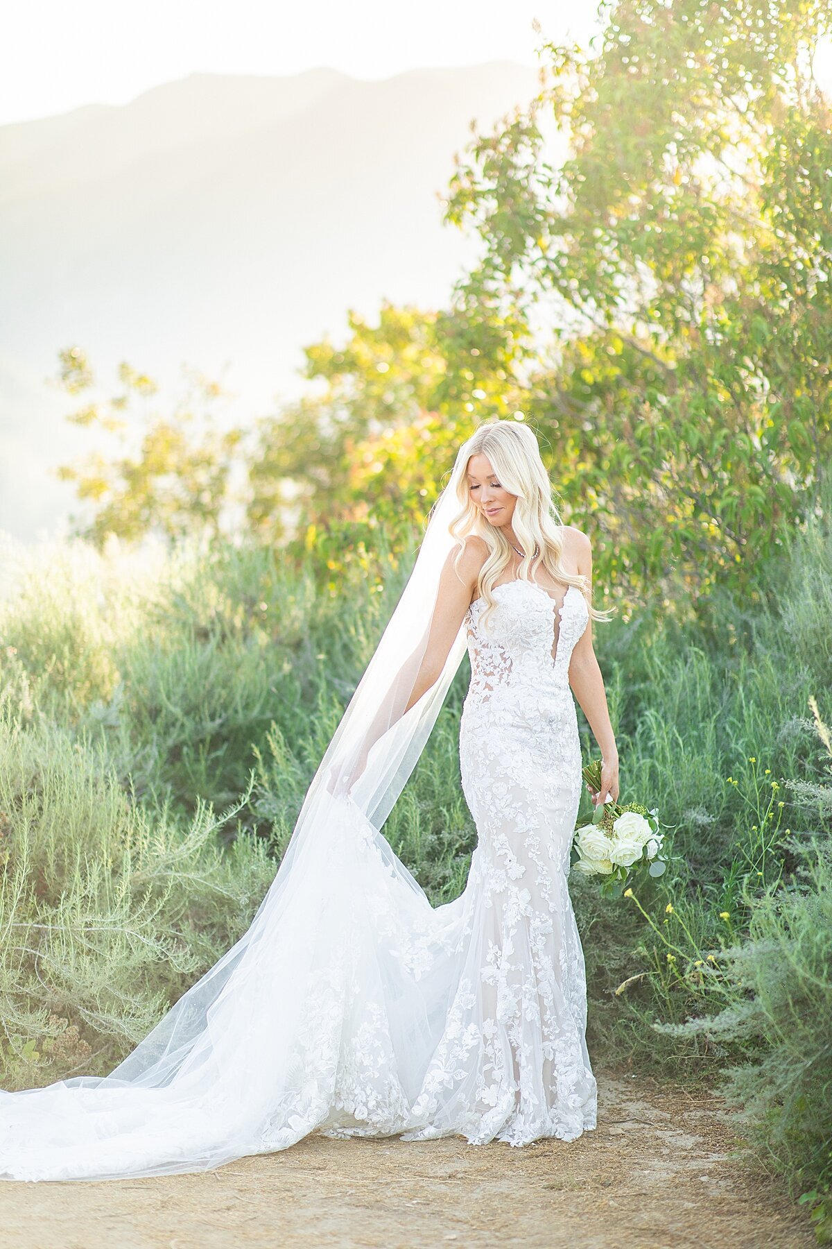 Bride holding gown at Circle Oak Ranch Estate in Fallbrook by Bree Sherr.