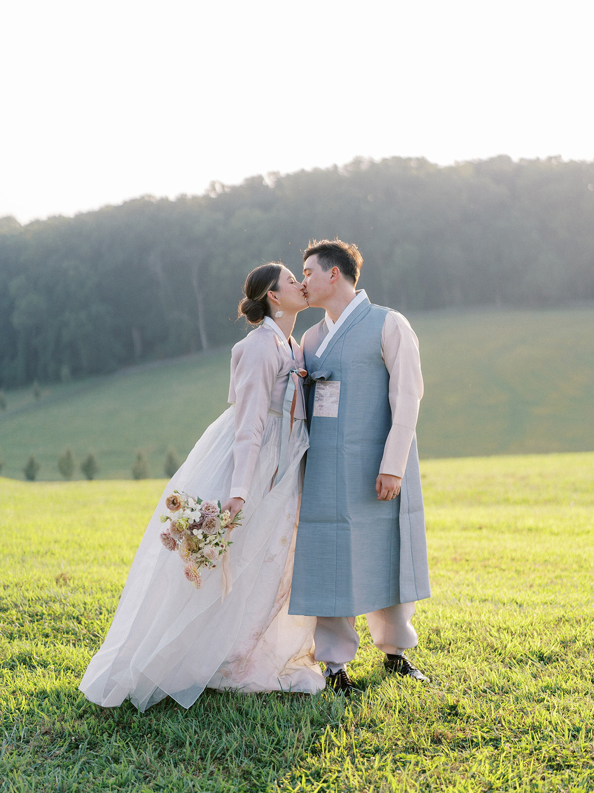 Portrait of the bride and groom in traditional Korean hanboks infront of Harford Hills landscape wedding venue in Fallston Maryland rolling hills