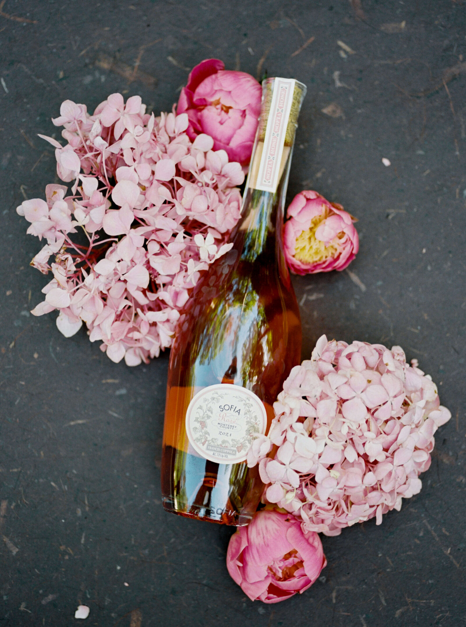 Virginia wedding photographer takes a picture of a special bottle of sparkling rose and pink flowers at a wedding