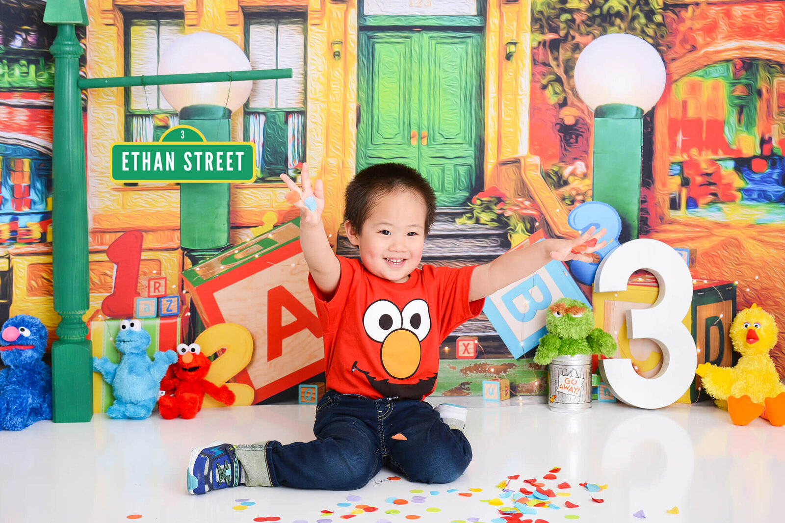 boy throws confetti at his first birthday photo session