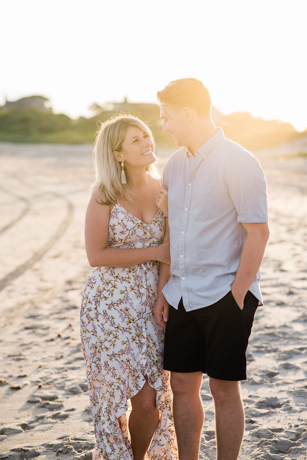 couple looking at each other on beach at golden hour