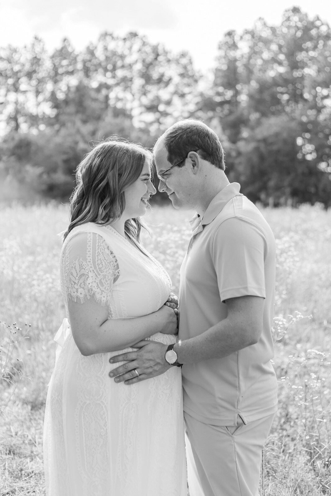 Pregnant couple looking into each others eyes smiling