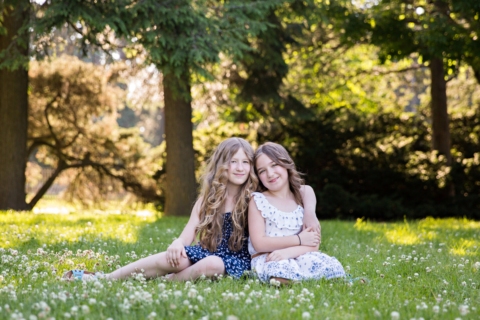golden hour sisters sitting in grass