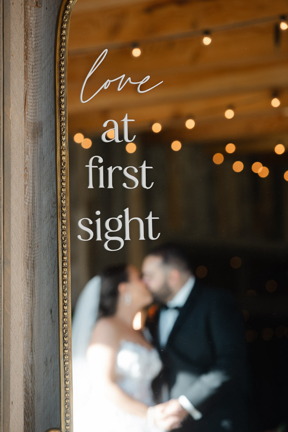 mirror with writing in foreground, out of focus couple in back