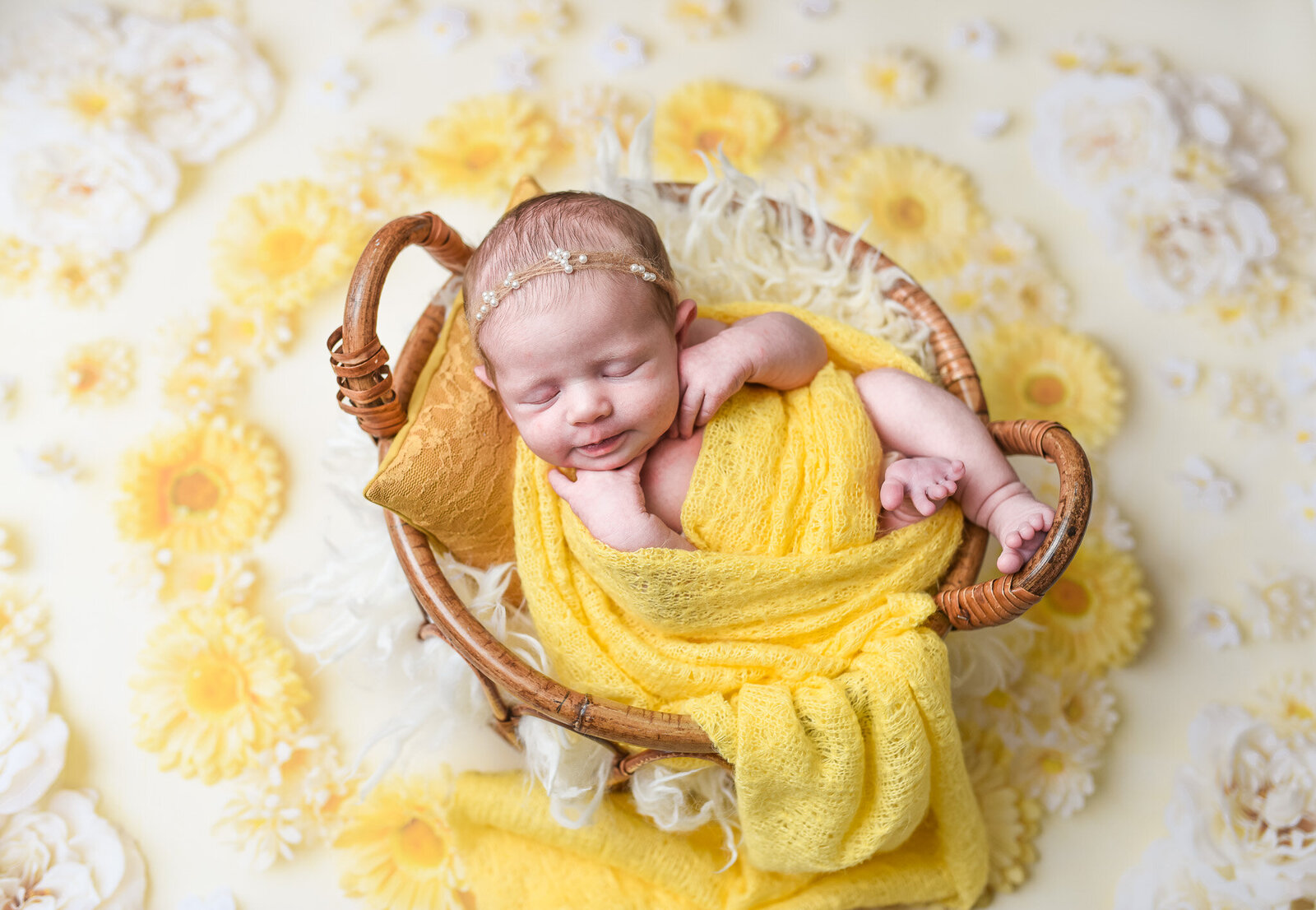 newborn baby laying on his side swaddled in a yellow blanket