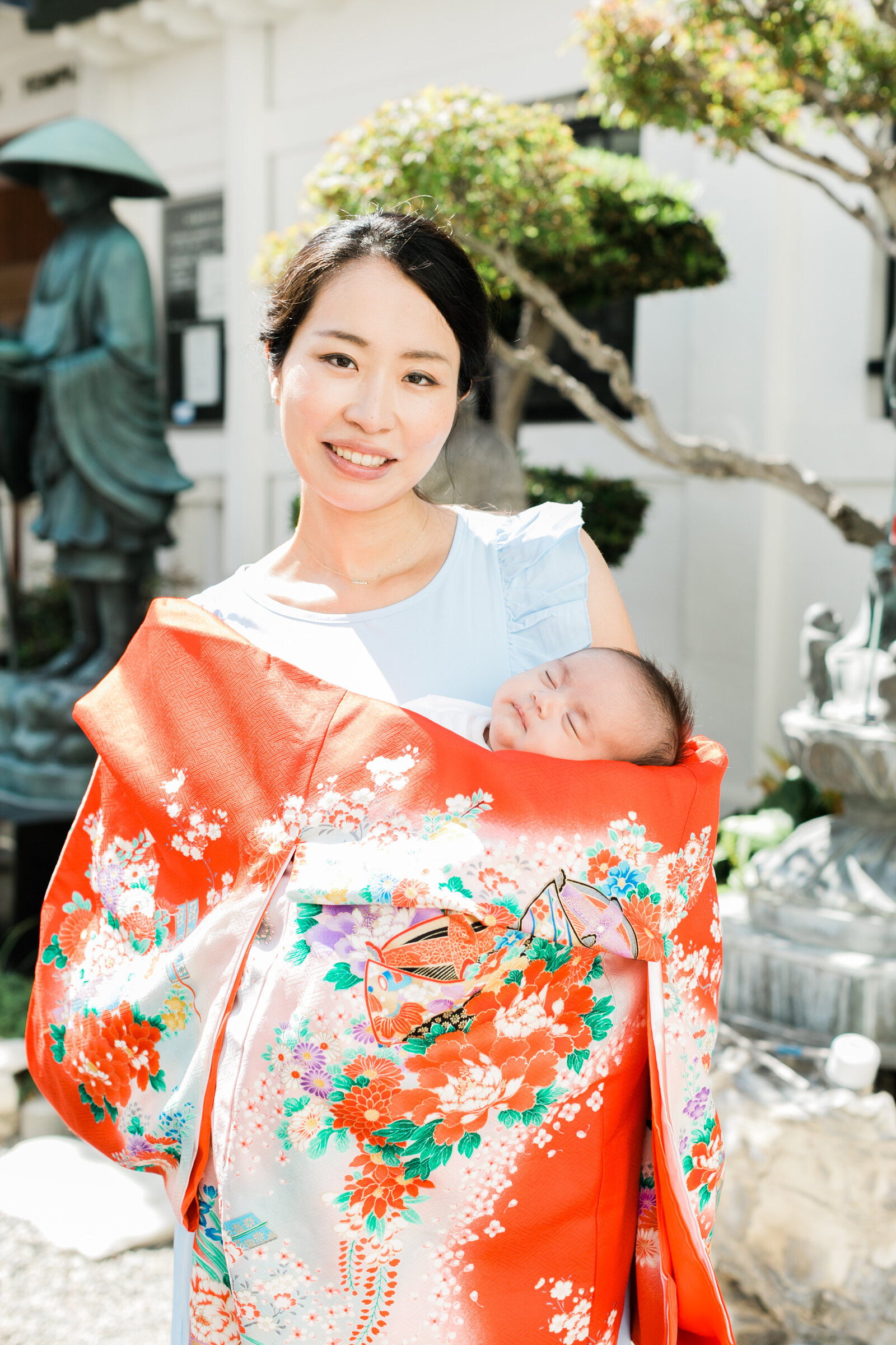 Mother holding baby in vibrant red kimono for Hatsumairi at Koyasan Buddhist Temple Los Angeles | 初参り 母と赤ちゃんのポートレート 高野山米国別院