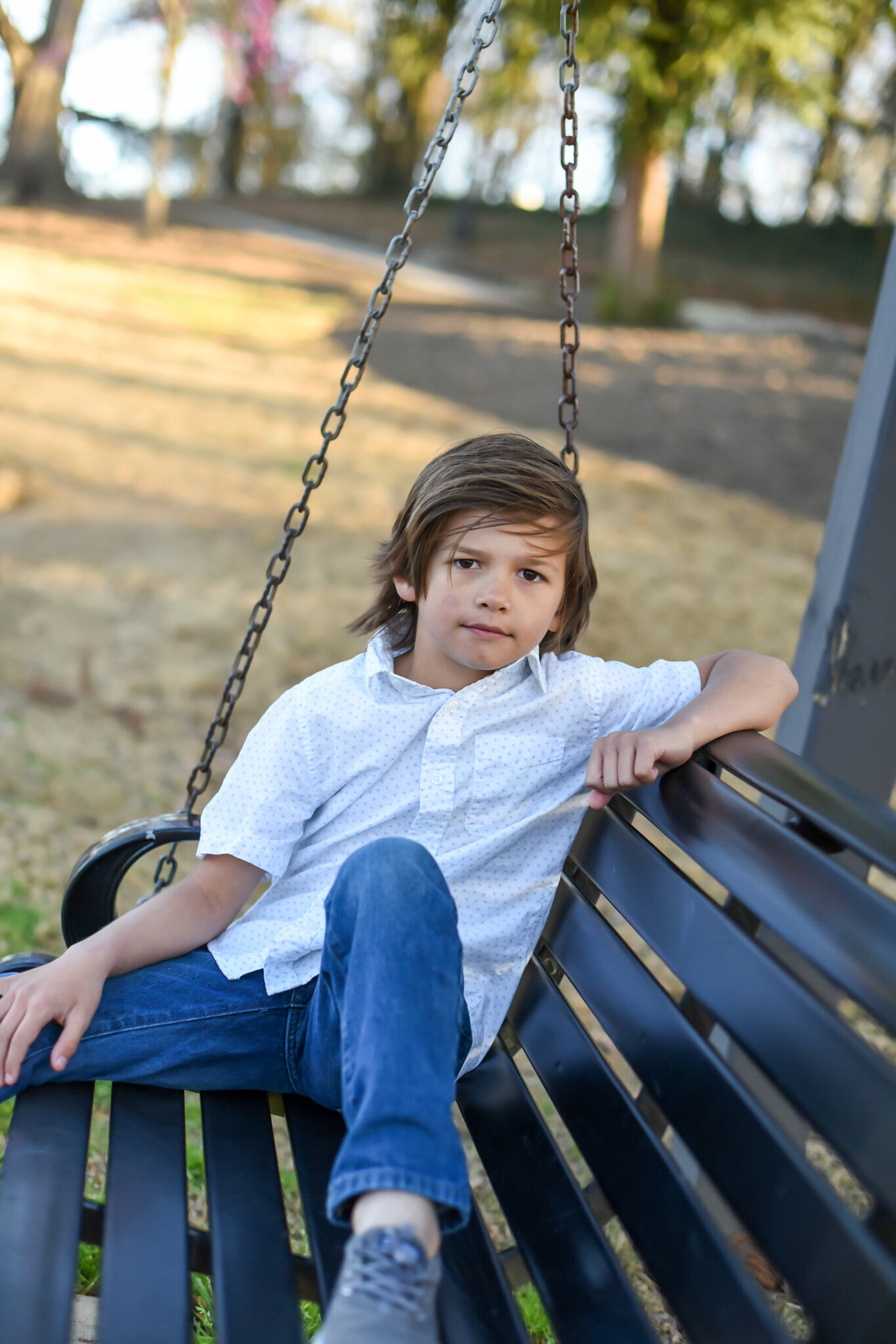 young boy on a bench swing  photographed by Millz Photography in Greenville, SC