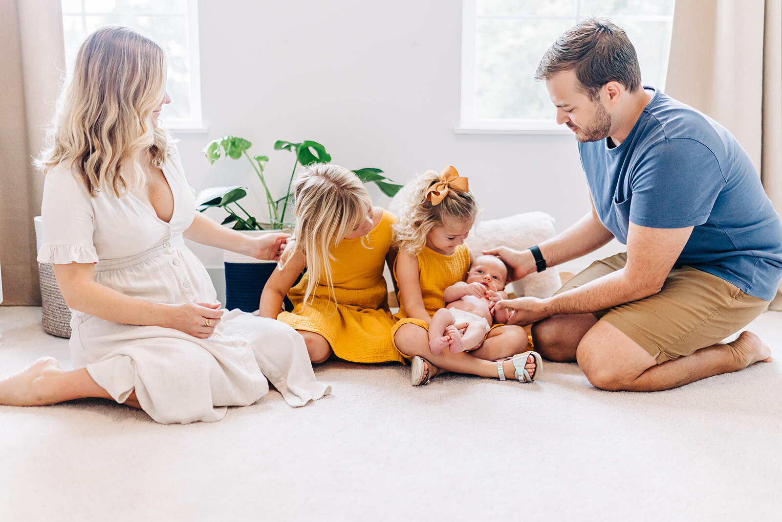 st pete family with two girls holding baby brother for the first time.