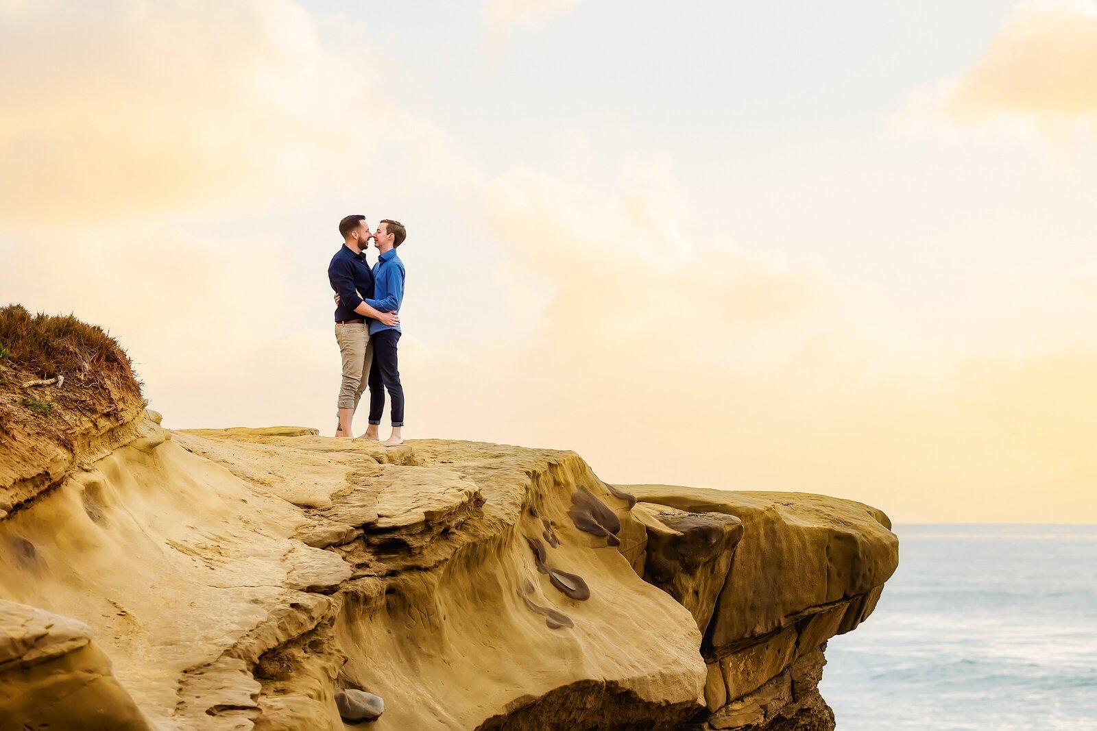 couple kissing on a cliff in San Diego