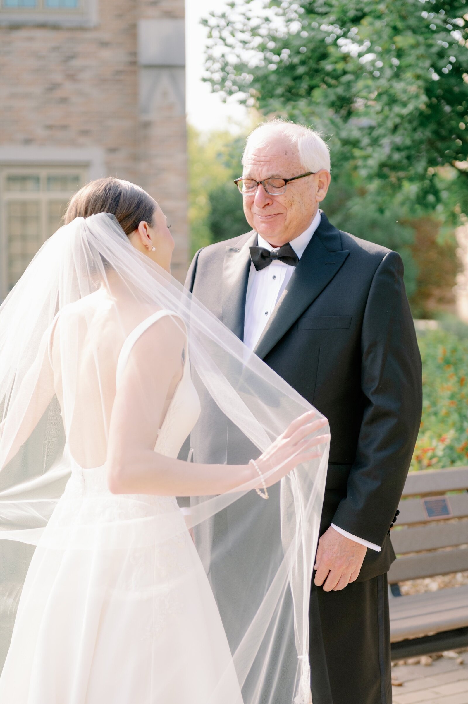 a man crying as his daughter shows him her wedding dress