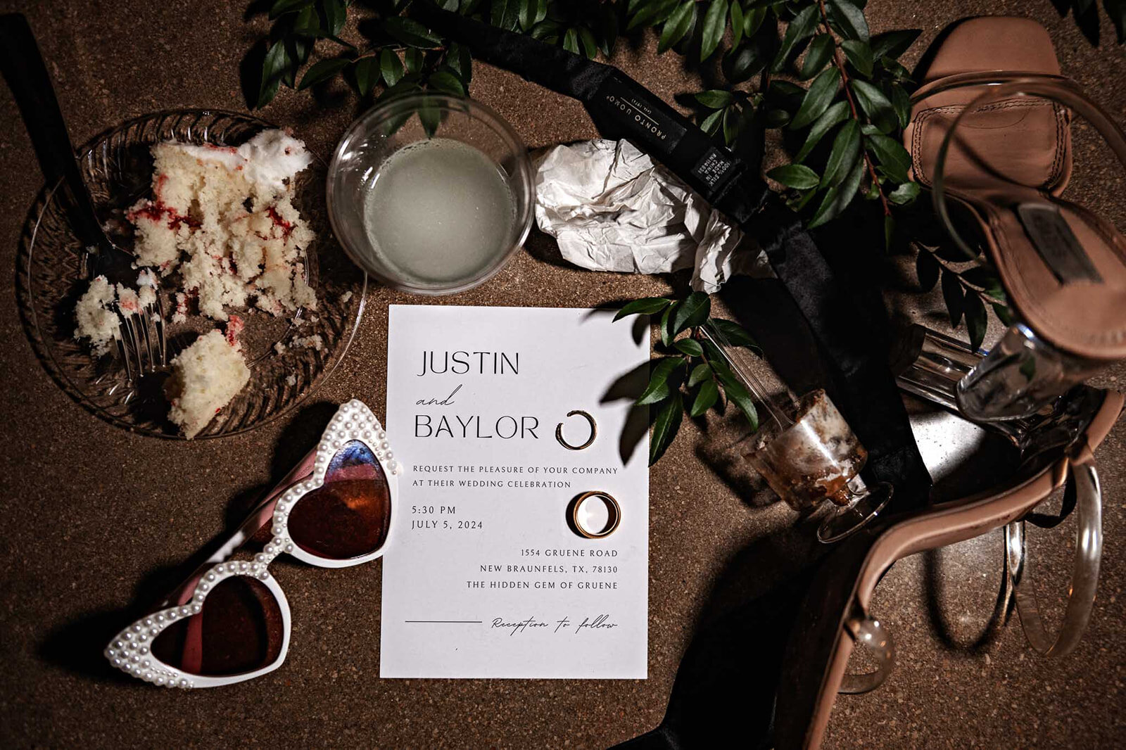 A close-up of a beautifully designed wedding invitation, captured alongside intricate wedding day details by CMH Studios