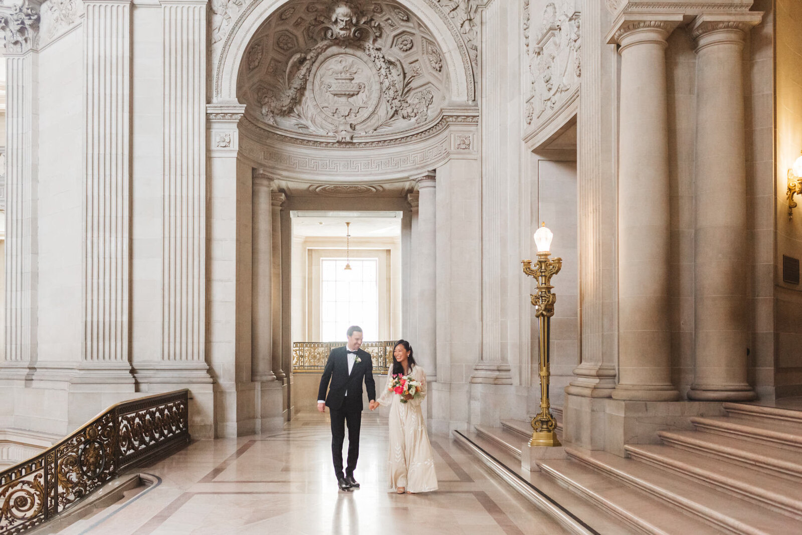 couple walking along the 2nd Floor of San Francisco City Hall on wedding day