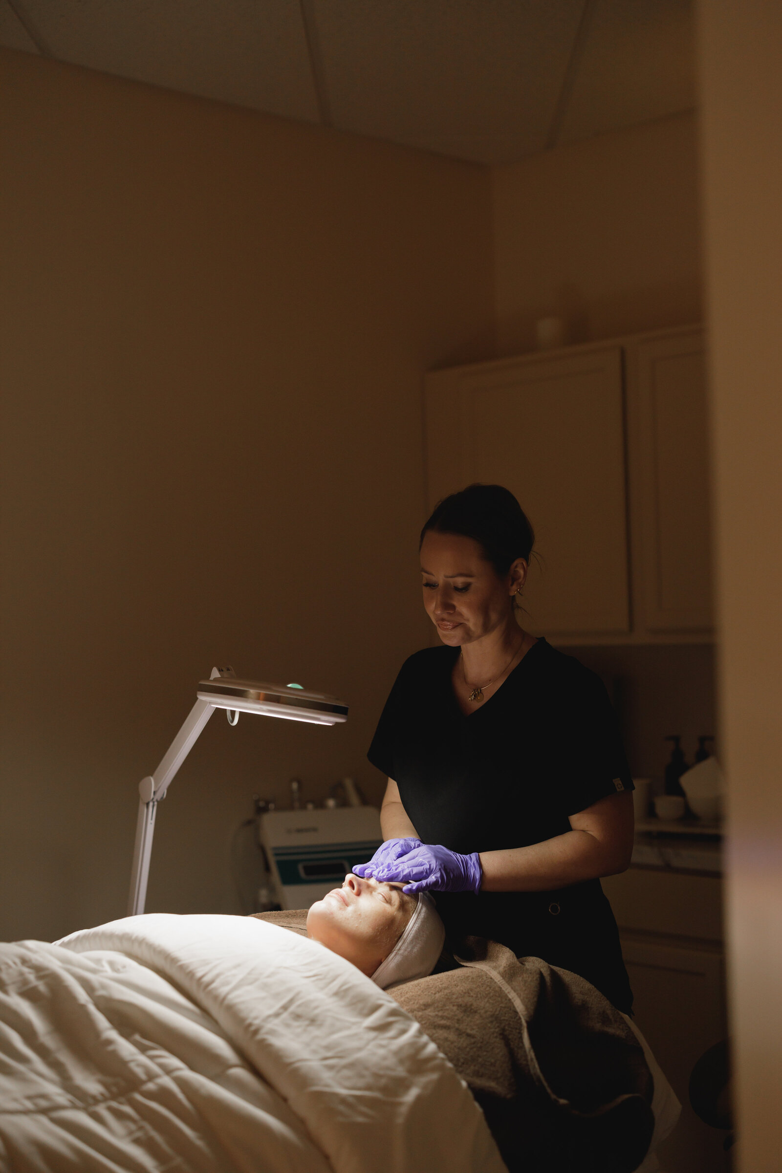 Karli giving a client a facial
