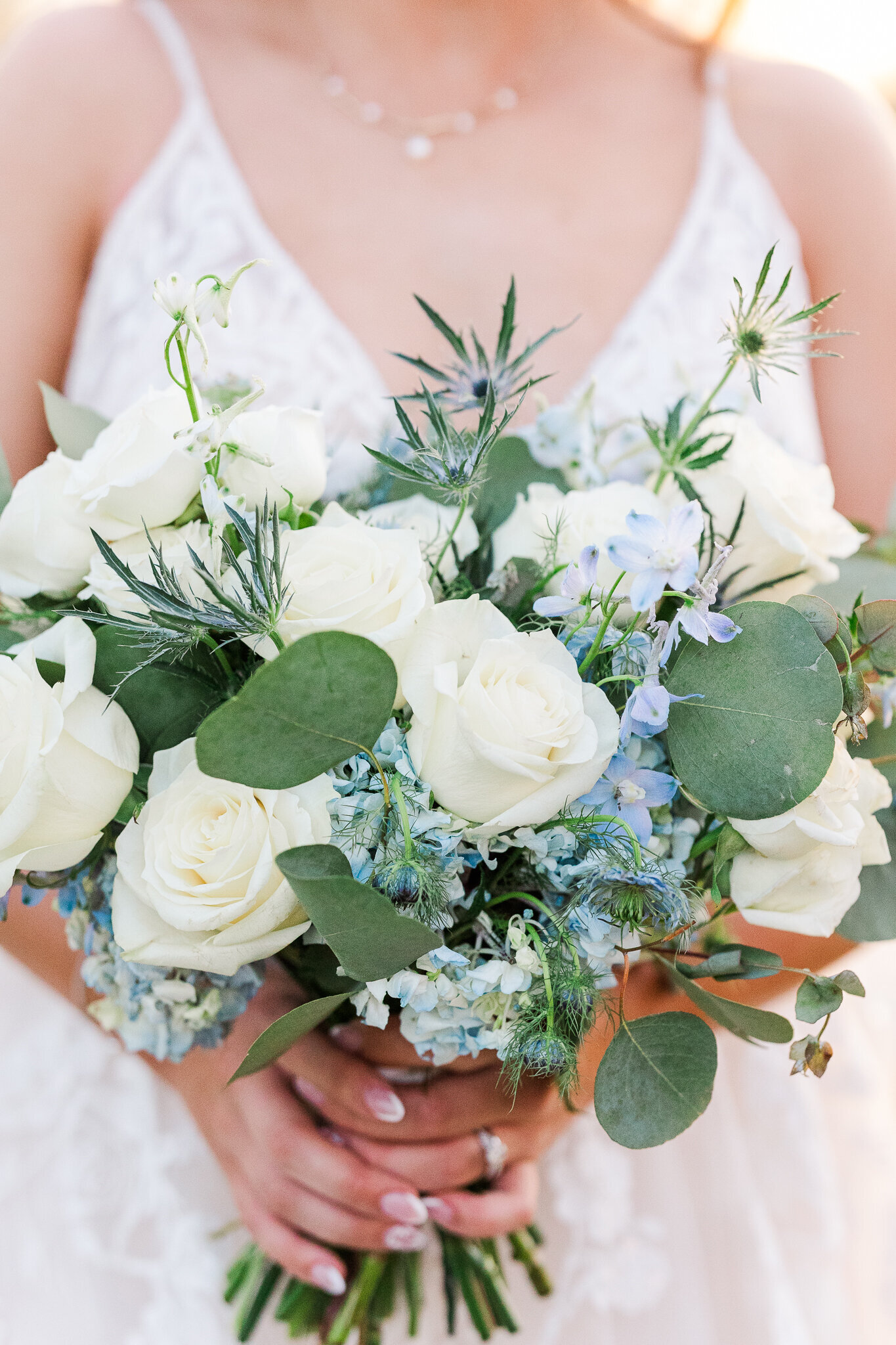 Bridal bouquet with soft blue, white, and greenery florals at a wedding in Loma, Colorado at Absolute Prestige Limo and Venue