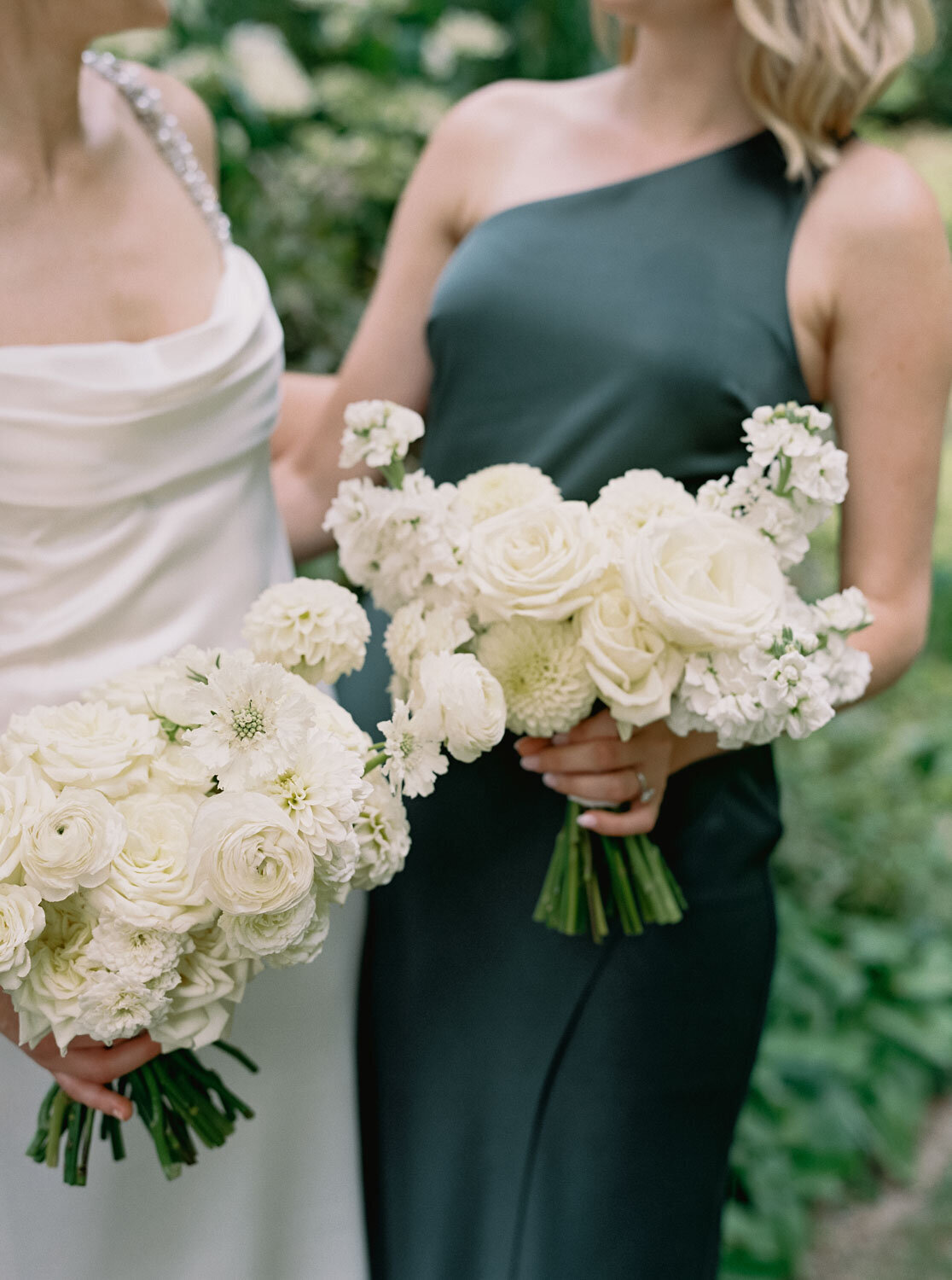 Bridesmaids holding white floral bouquets