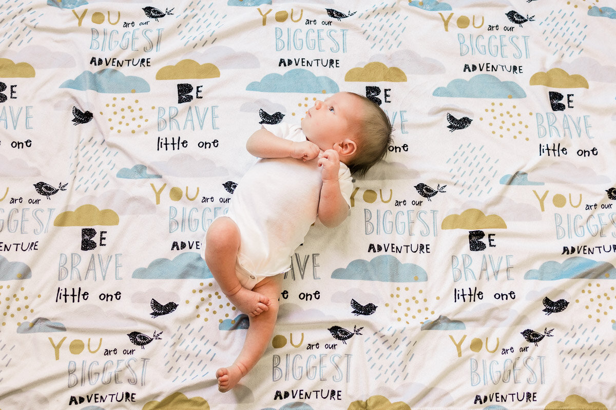 Newborn baby boy laying on blanket