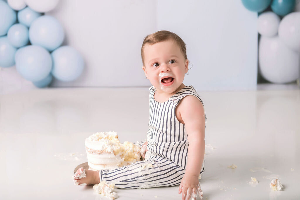 Portrait Photographers CT create memorable first birthday photos with blue balloon backdrop and cake smash