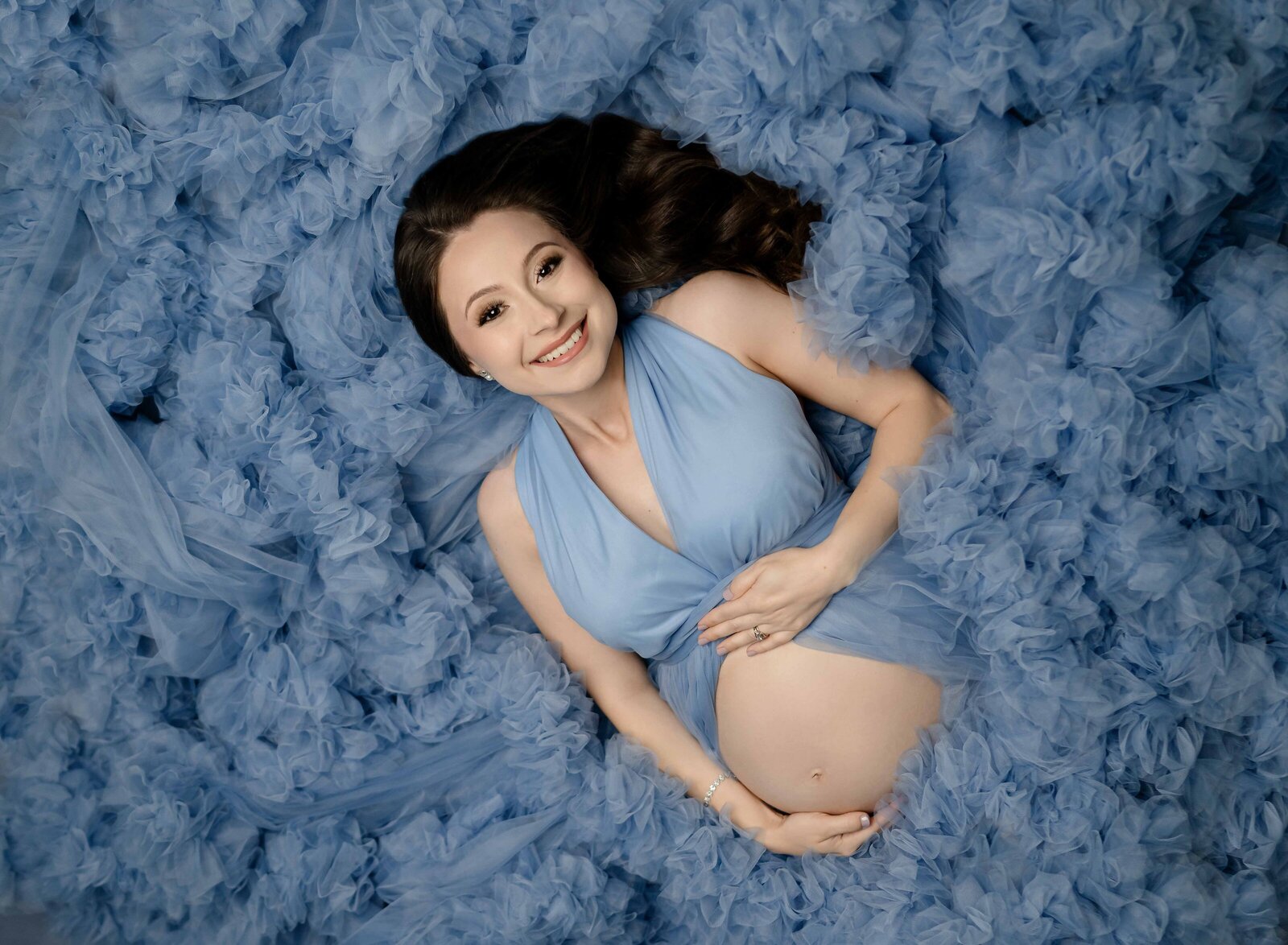 Blue ruffle dress with Mom laying down and holding baby bump. Maternity Photo by Jenni Nikki Photography, Atlanta maternity Photographer.