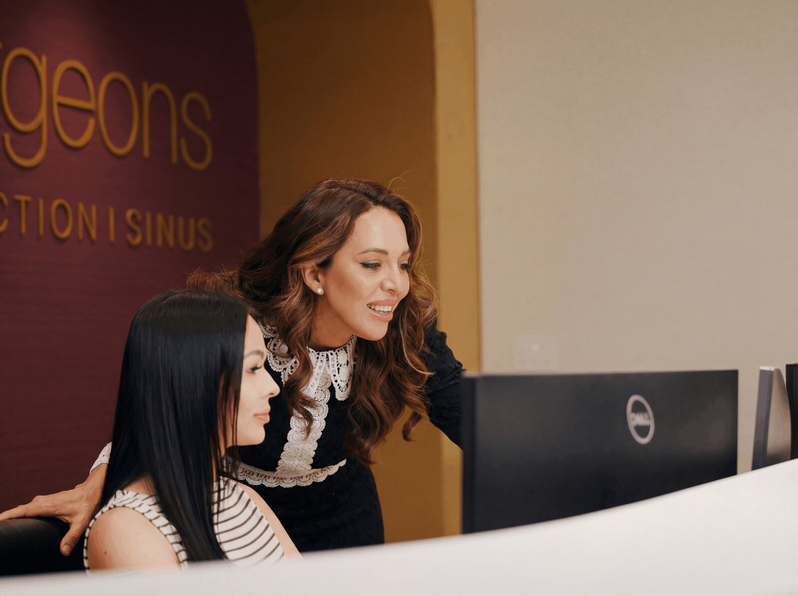 Two front desk team members looking at a computer screen