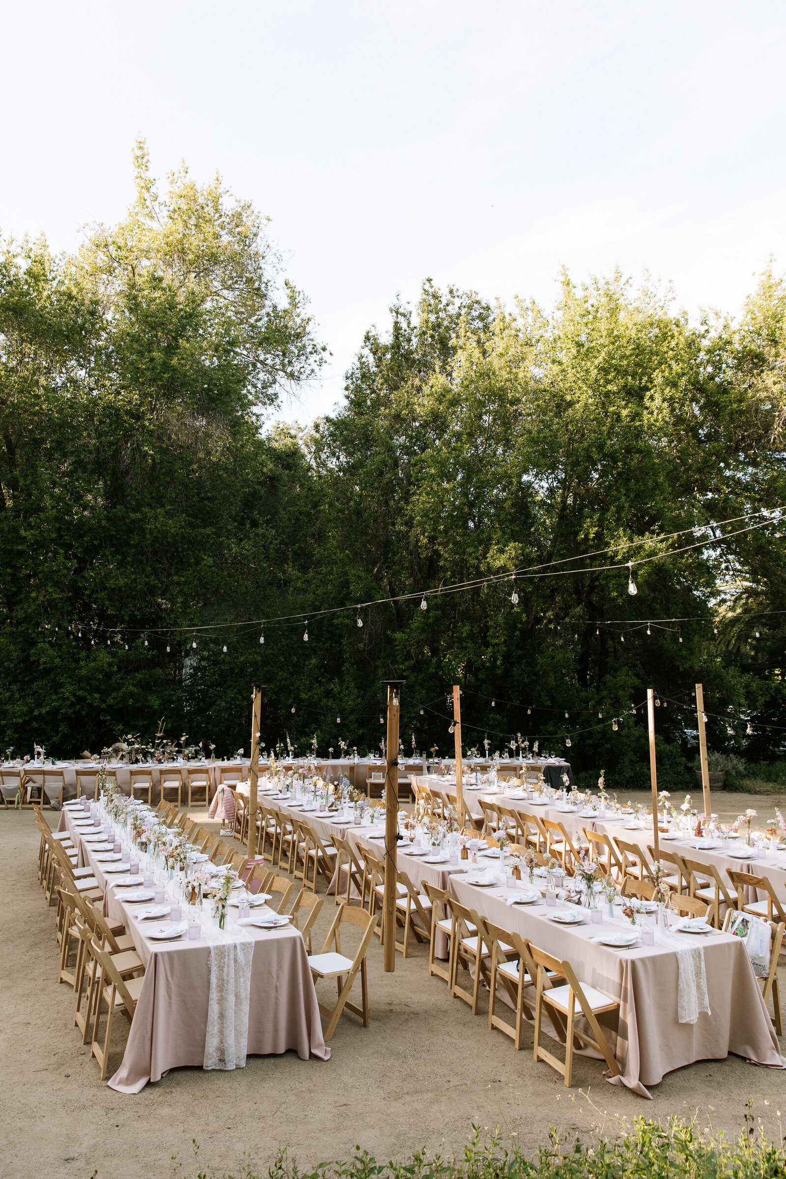 Candlelit outdoor wedding reception setup with greenery in McCall garden venue