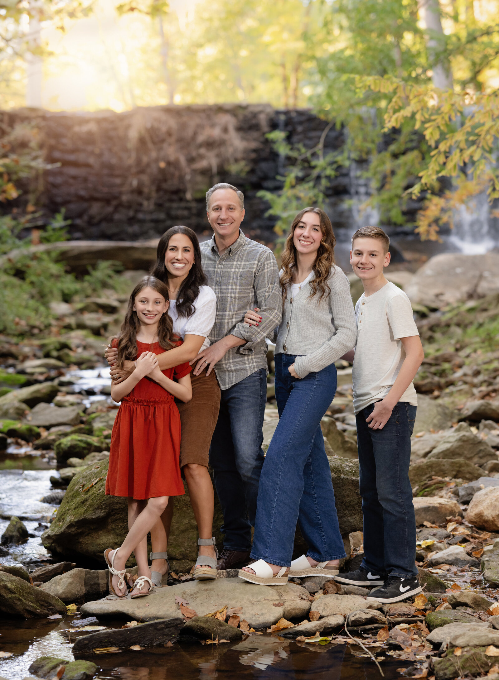 Family standing in creek and smiling at camera for Family photo shoot in Atlanta.