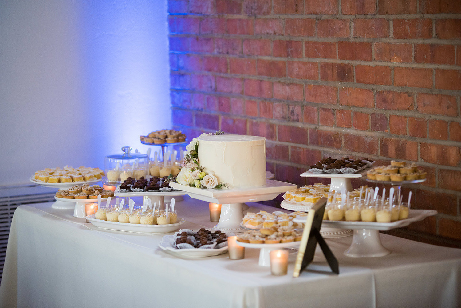 beautiful photo of reception room at brick dessert table