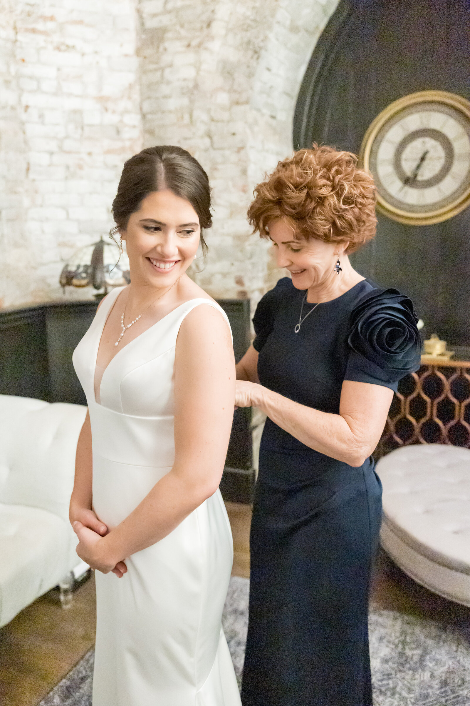 mom helps bride into dress