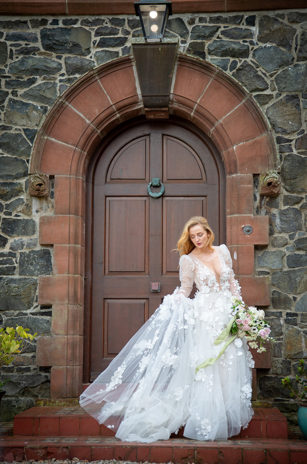 bride swishes her dress in front of door and shone wall