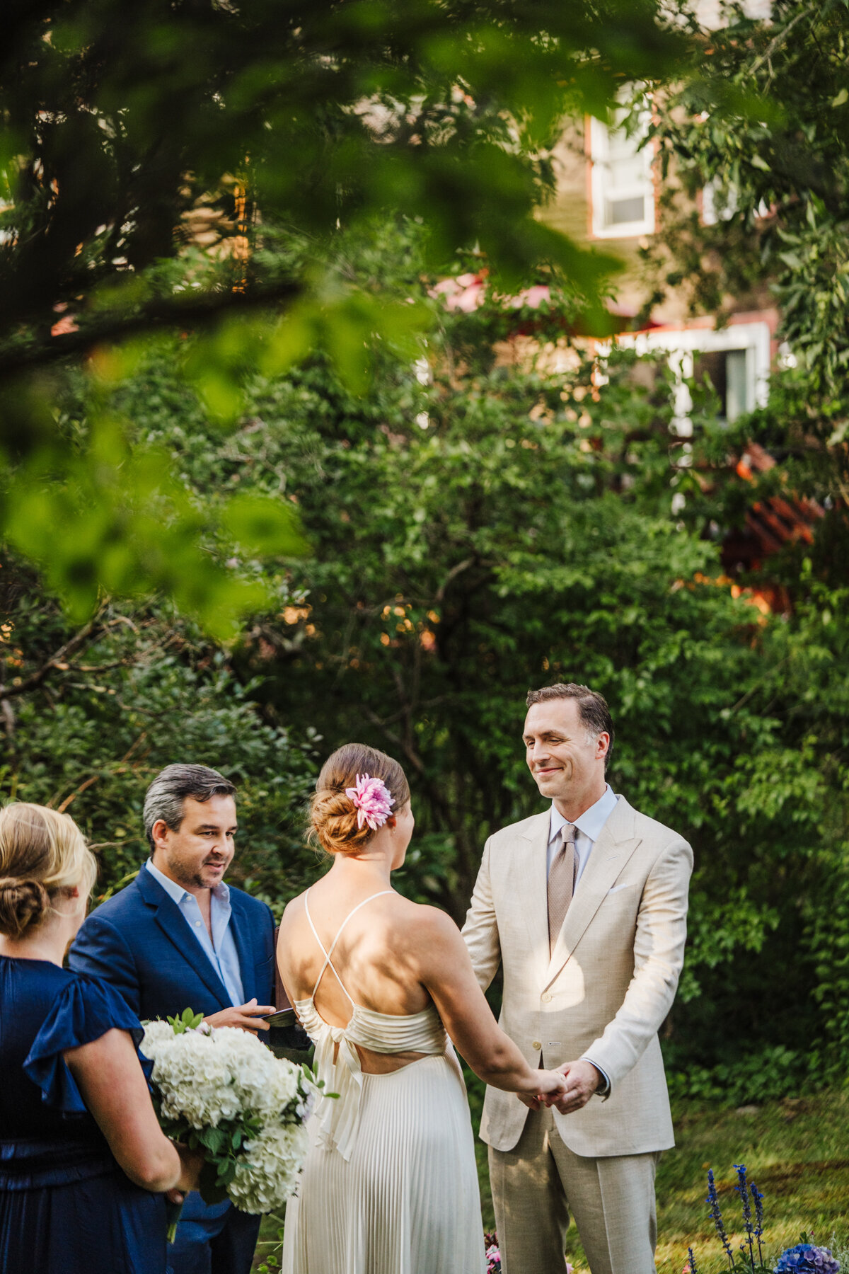 ceremony between bride and groom in backyard in massachusetts