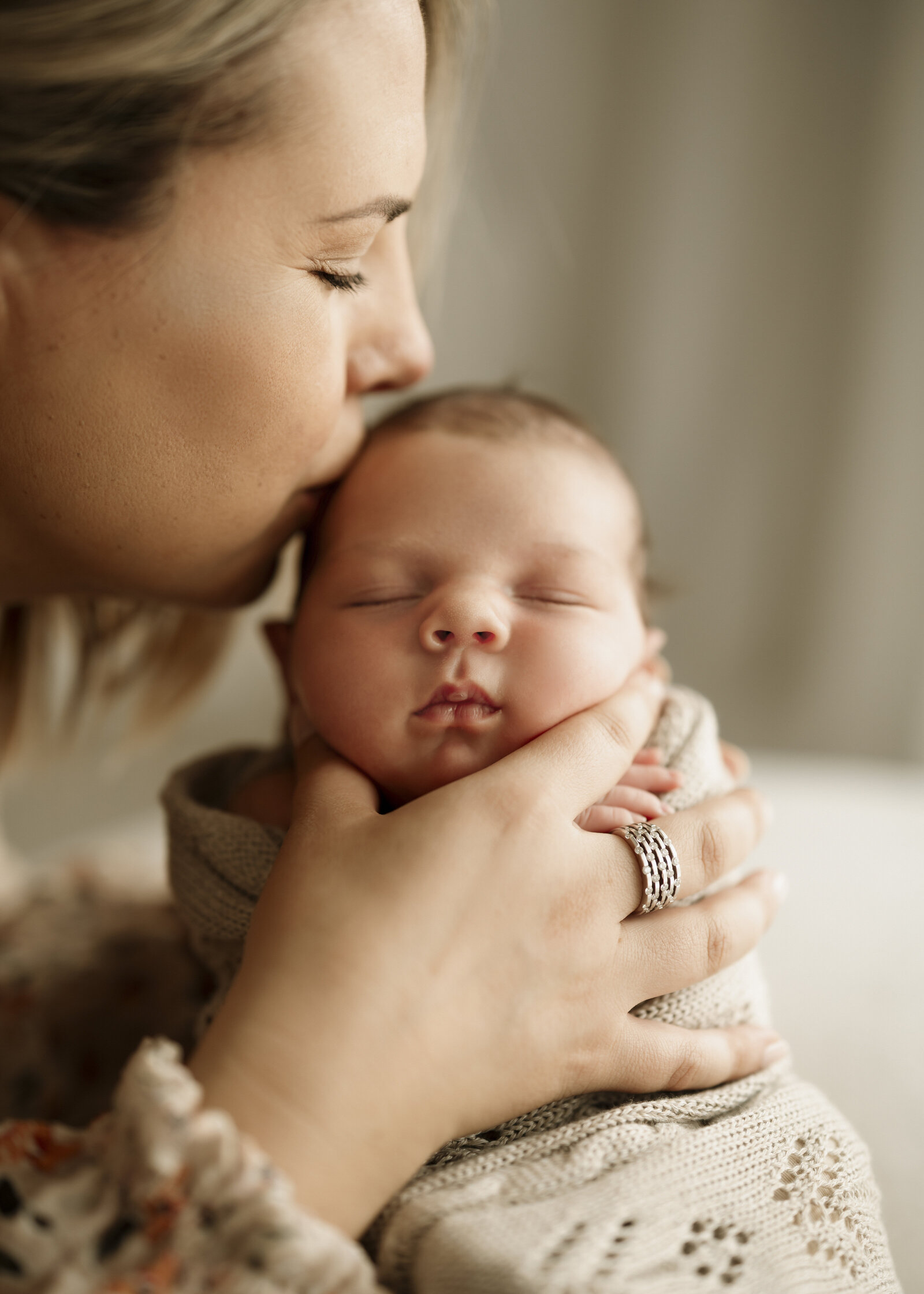 Mum, dad, and baby in a Perth studio newborn photoshoot, capturing the joy of welcoming a new addition to the family.