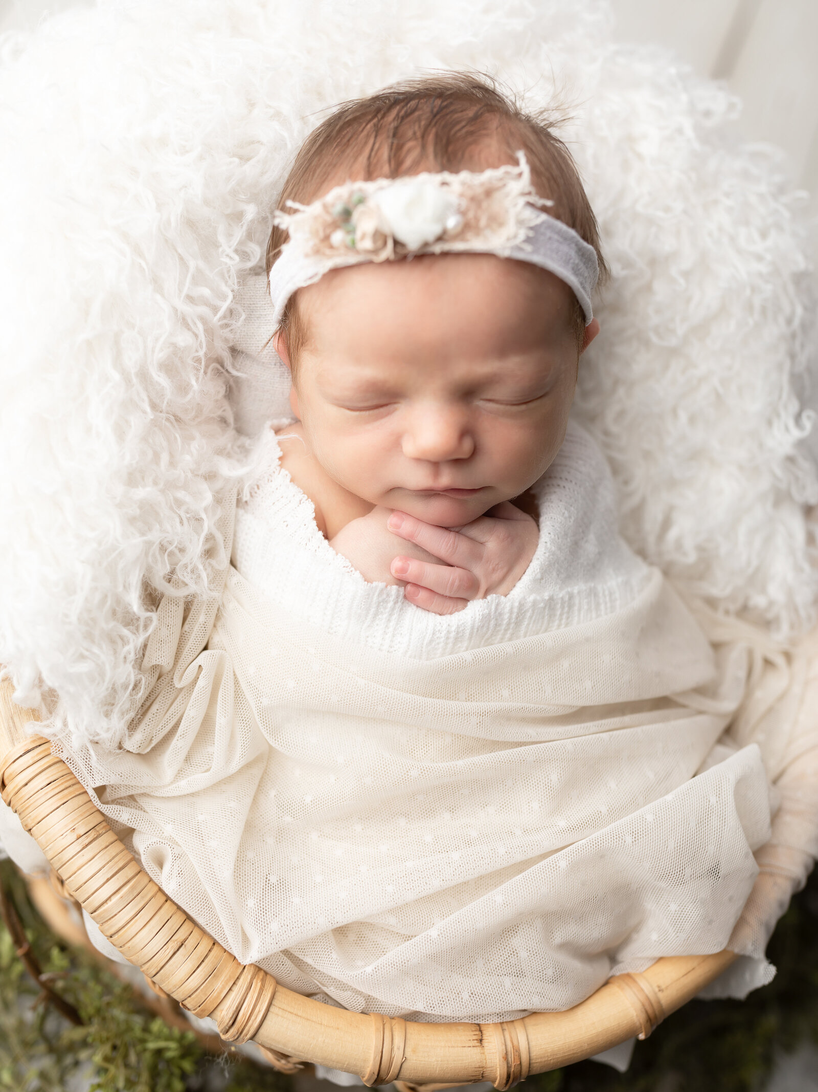 newborn baby girl wrapped in white for studio portrait