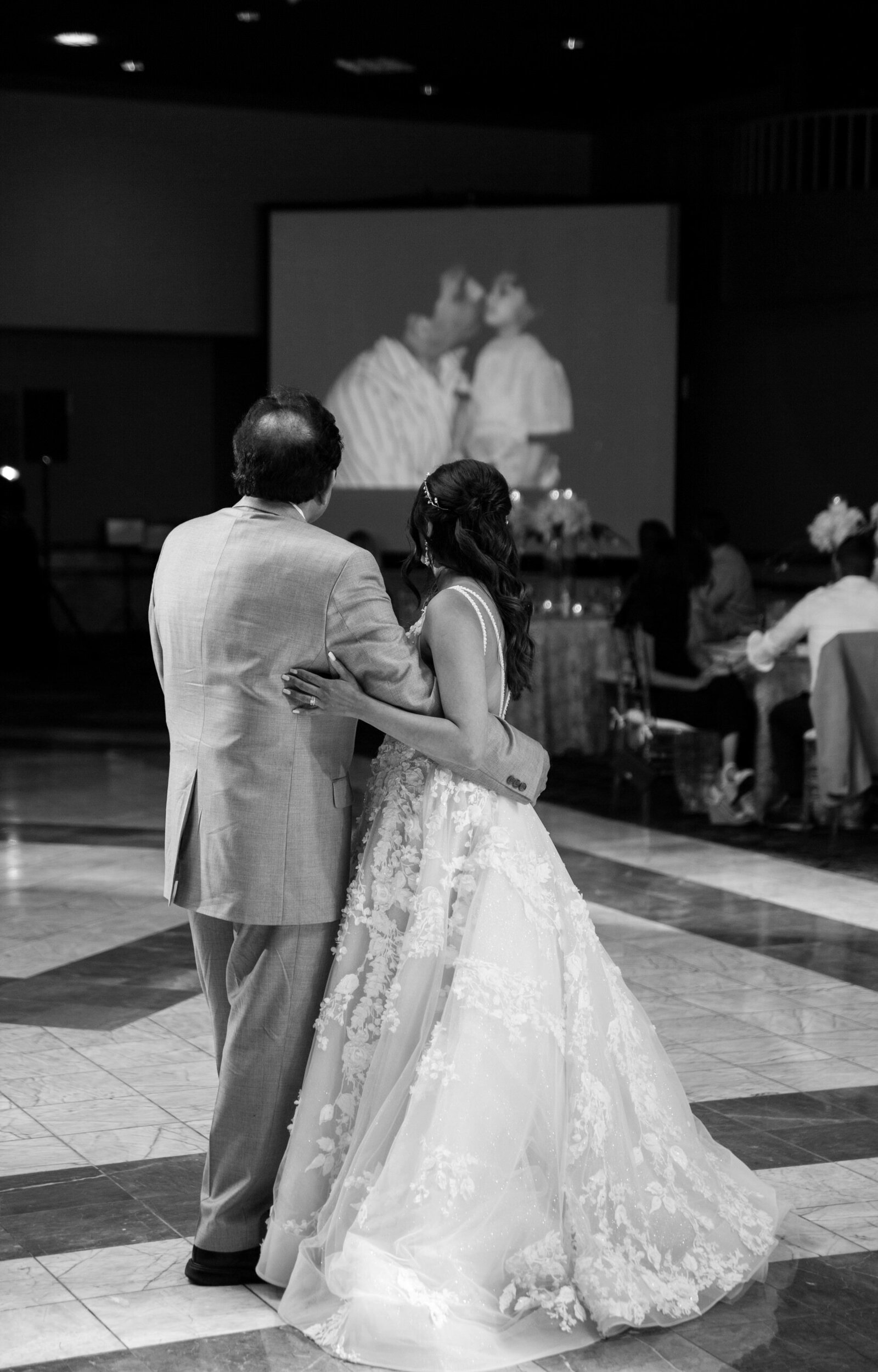 bride and her father dancing while looking at a powerpoint