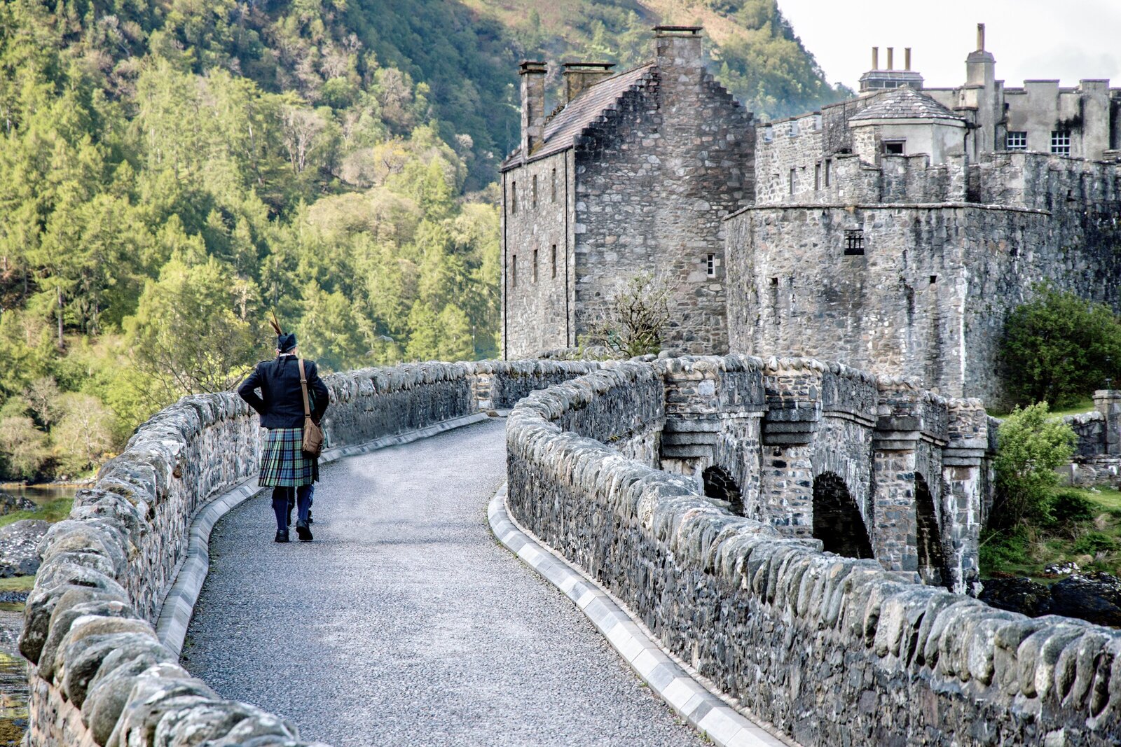 Eilean Donan Castle with Scottish man on bridge