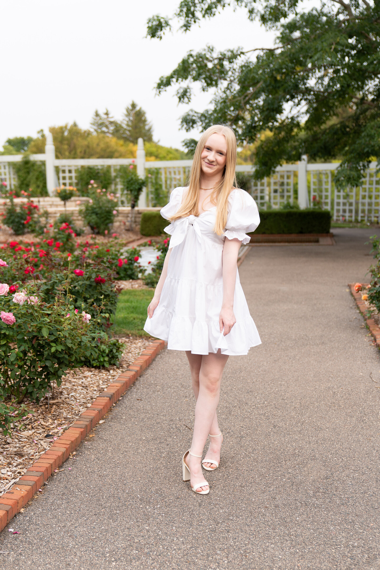 Girl walks toward the camera during her senior pictures at the Minnesota Landscape Arboretum in Chaska, Minnesota.