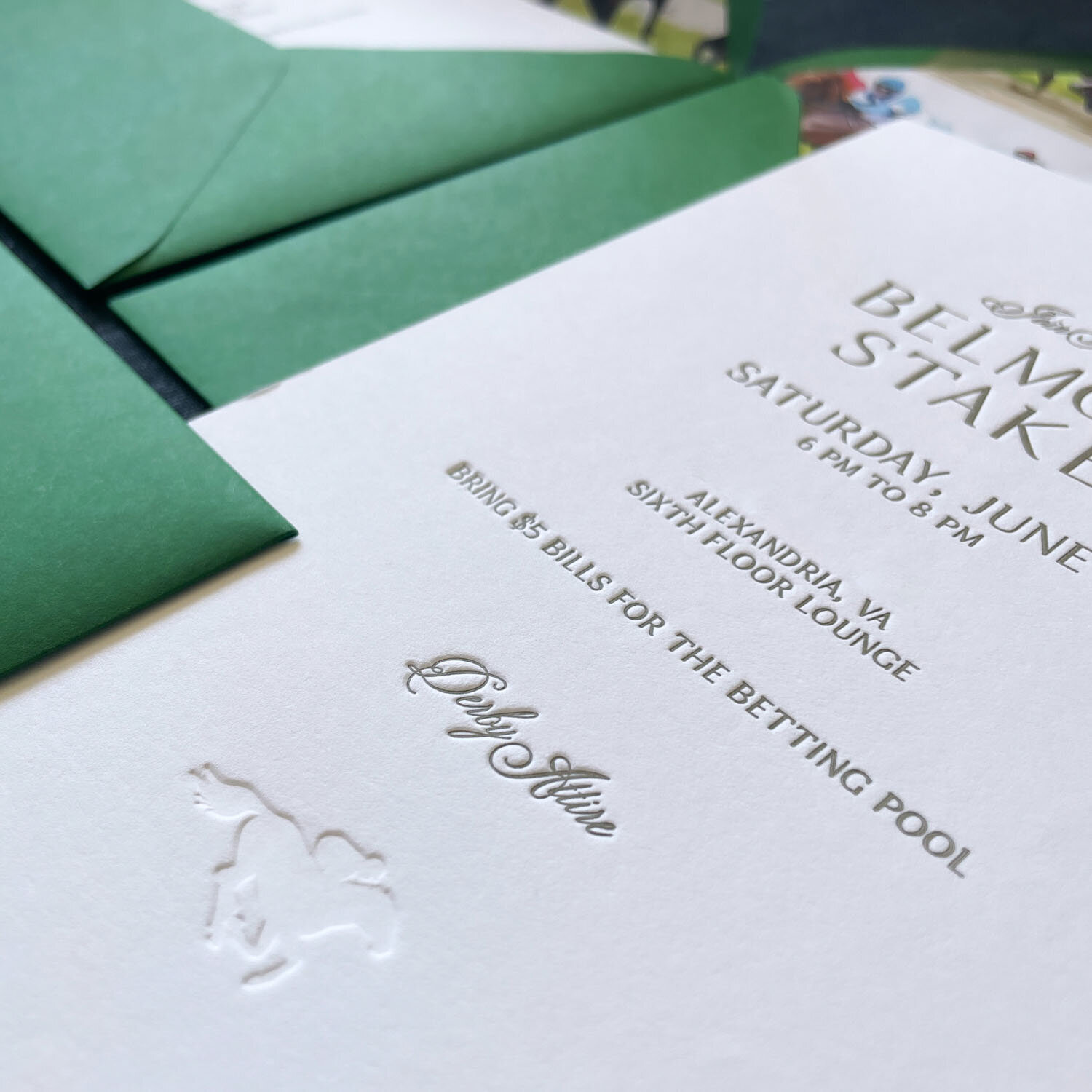 Embossed invitation for a horse racing event with green envelopes.