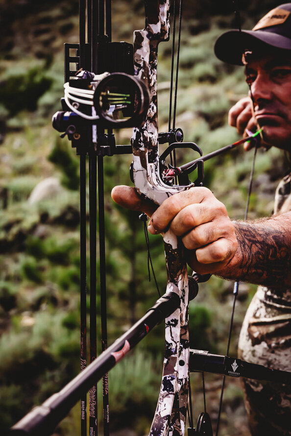 Close up of arrow as a bow hunter pulls the bow back.