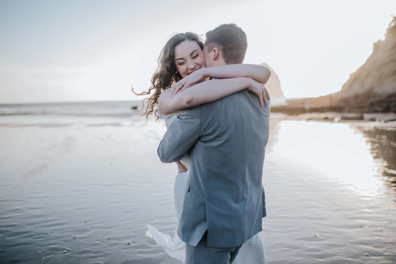 Lake Tahoe wedding photographer captures couple hugging on beach at sunset