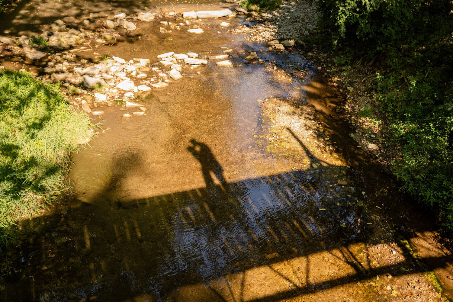 Shadow of bride and groom kissing in the bridge